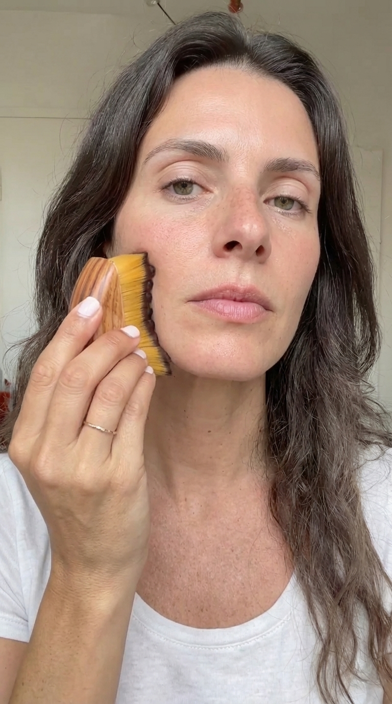 Woman using guabrasha sculpting brush at her cheekbone